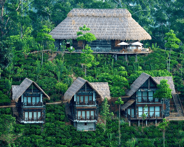 Aerial view of luxury thatched-roof villas nestled in green hills