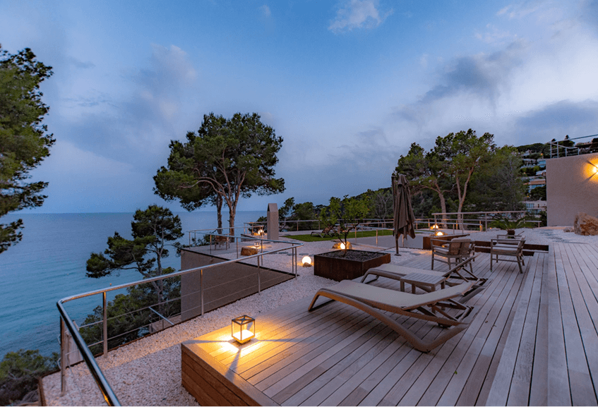 Luxury terrace overlooking the ocean at twilight with ambient lanterns