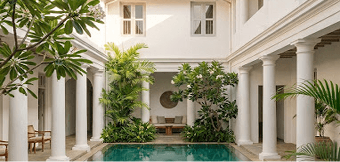 Luxury villa courtyard with a turquoise pool and white colonnades