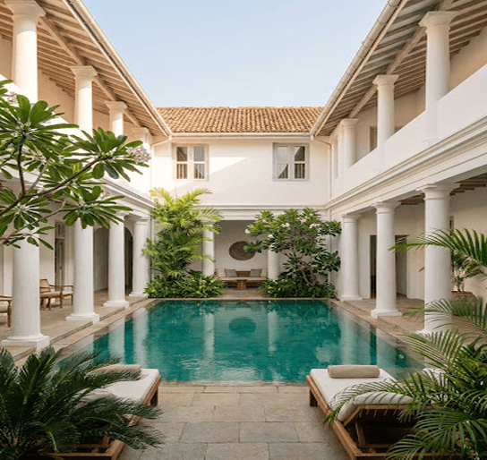 Luxury villa courtyard with a turquoise pool and white colonnades